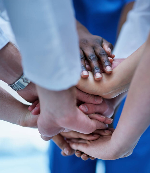В согласии с вашим лечением. Обрезанный снимок команды врачей, объединяющих свои руки в знак солидарности. - Фото, изображение