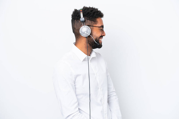 Telemarketer Brasilialainen mies työskentelee kuulokkeet eristetty valkoisella taustalla nauraa sivusuunnassa - Valokuva, kuva