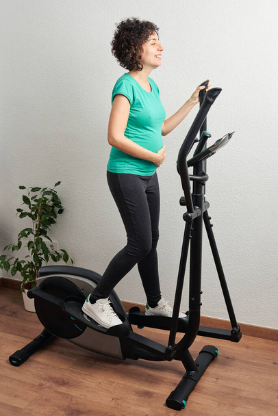 terhes nő gyakorolja otthon - Fotó, kép