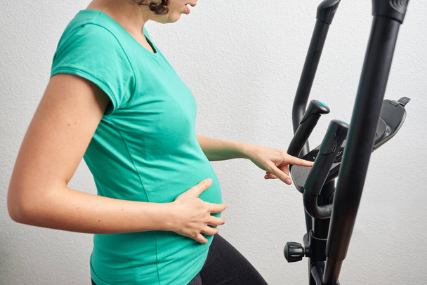Tanımlanamayan hamile kadın evde egzersiz yapıyor. - Fotoğraf, Görsel