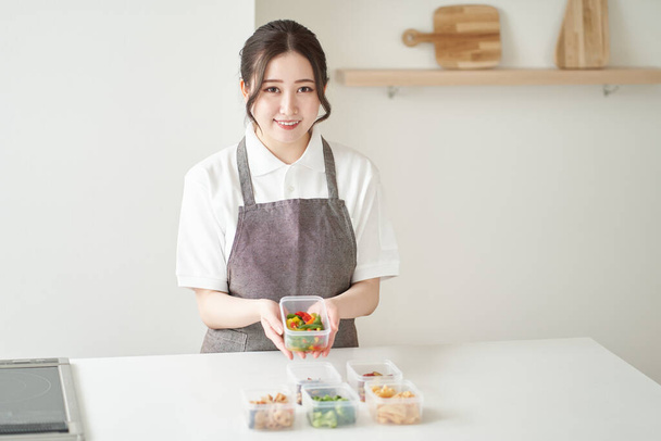 азіатська жінка готує на кухні
 - Фото, зображення