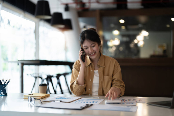 Mujer de negocios o contable de auditoría de trabajo mientras llama a consultor su equipo. concepto financiero y contable - Foto, Imagen