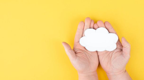 white cloud with hand on yellow background. - 写真・画像