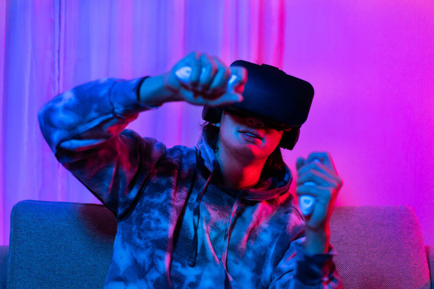 Людина носить окуляри віртуальної реальності і використовує джойстик, щоб грати в ігри з розвагою, VR, Future Games, Technology, Red і синій фон, Touch Controller, Bluetooth Remote Controller, VR концепція гри. - Фото, зображення