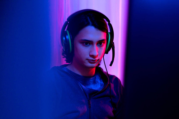 Young men play E-Sport games or streamers, Male enjoying playing online games, entertainment  or technology game trends, Professional live performance, Focus monitor, Red and blue background. - Foto, Imagen
