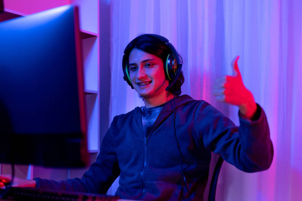 Men play E-Sport games or streamers, Thumbs up or like, Male enjoying playing online games, entertainment  or technology game trends, Professional live performance, Red and blue background. - Foto, Imagen
