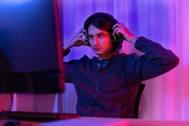 Young men play E-Sport games or streamers, Male enjoying playing online games, entertainment  or technology game trends, Professional live performance, Focus monitor, Red and blue background. - Foto, imagen