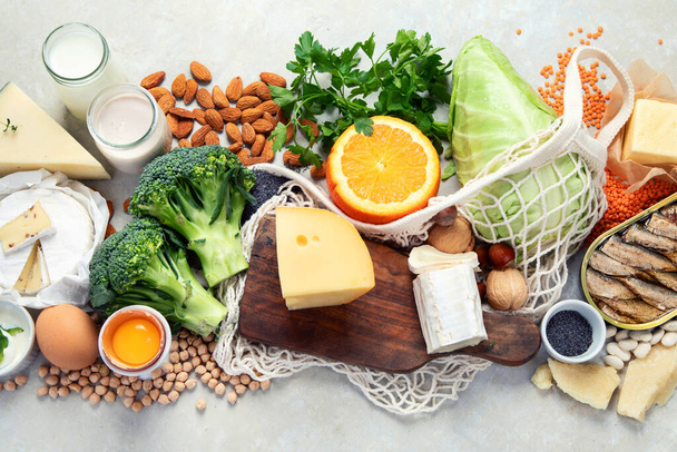Healthy food high in calcium on light background. Dairy products, vegetables and superfoods. Ca products. Top view, flat lay, copy space - Foto, afbeelding