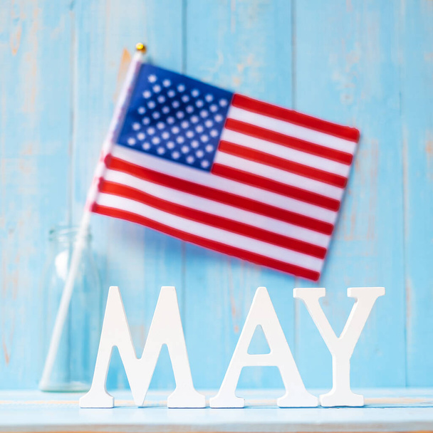 KVĚTEN text a vlajka Spojených států amerických na dřevěném pozadí stolu. Happy Memorial den a sváteční oslavy koncepty - Fotografie, Obrázek