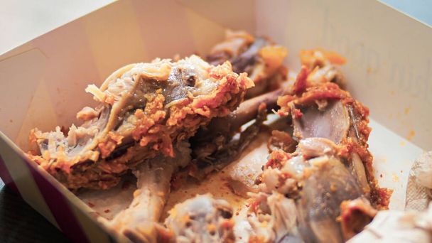Conceito de desperdício alimentar. Ossos de frango frito em um restaurante - Foto, Imagem