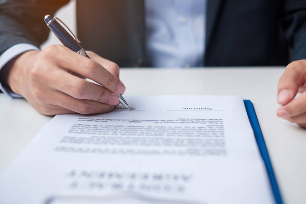 man signing on contract documents after reading, man holding pen and approve on business report. Contract agreement, law and deal concepts - Photo, Image