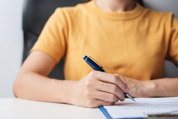 Vrouw die tekent op contract documenten na het lezen, hand vasthouden pen en goed te keuren op zakelijke rapport. Contractovereenkomst, partnerschaps- en dealconcepten - Foto, afbeelding