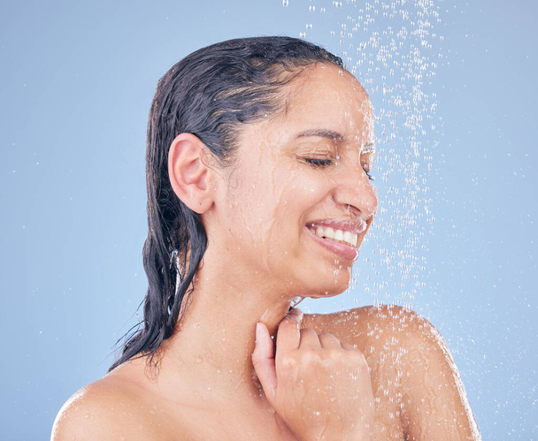 Щастя це лише душ. Знімок красивої молодої жінки, що приймає душ на синьому фоні
. - Фото, зображення