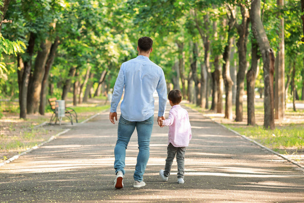 Ojciec spacerujący ze swoim synkiem w parku - Zdjęcie, obraz
