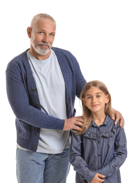Senior man met zijn kleine kleindochter op witte achtergrond - Foto, afbeelding