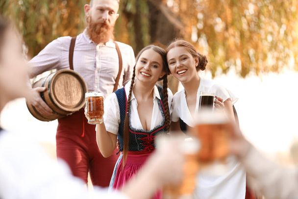 Gente con cerveza celebrando Octoberfest al aire libre - Foto, imagen