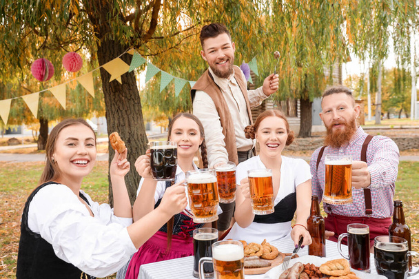 Ludzie z piwem świętują Octoberfest na świeżym powietrzu - Zdjęcie, obraz