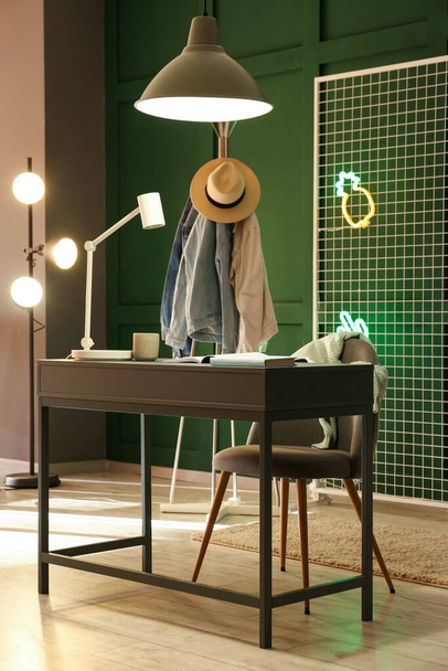 Modern workplace, rack with clothes and glowing lamps in dressing room - Photo, Image