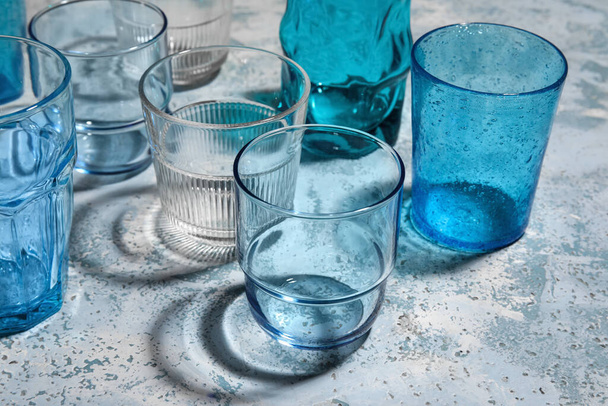 Different empty glasses on light blue background - Photo, Image