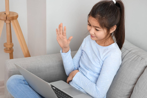 Little Asian girl asking her online tutor question at home - 写真・画像