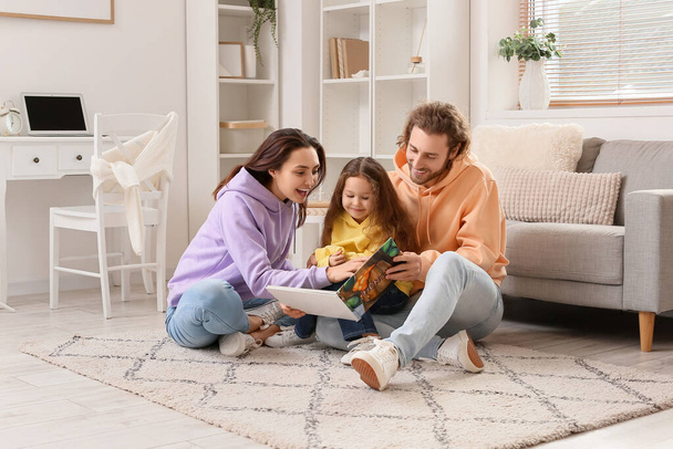 Młoda rodzina czyta książki razem w domu - Zdjęcie, obraz