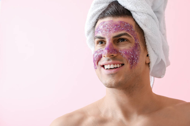 Jóképű férfi csillámos maszk és törölköző rózsaszín háttér - Fotó, kép