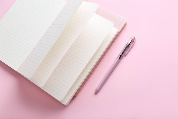 notebook a pero na růžovém pozadí - Fotografie, Obrázek