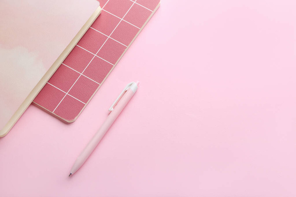 Notebookok és toll rózsaszín háttérrel - Fotó, kép