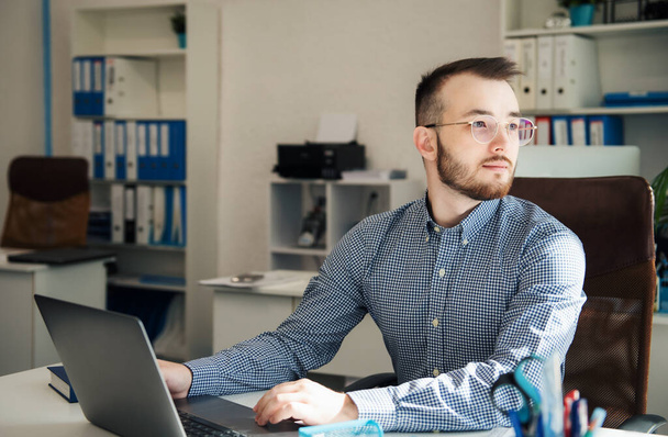 Young Businessman in shirt working on his laptop in an office - Foto, imagen
