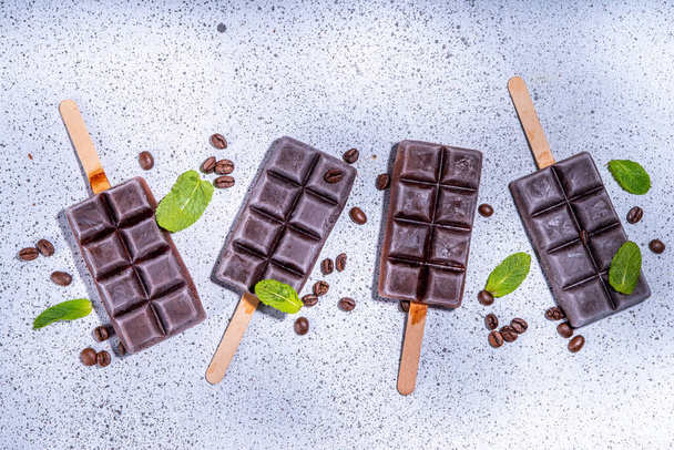 Coffee espresso ice cream popsicle, tasty dark coffee lollypops, summer healthy vegan frozen dessert. On white background with  coffee beans and mint leaves - Fotografie, Obrázek