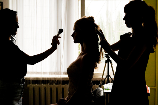 beauty salon, the girl makeup and styling in the salon, hairdressers and make-up artist in contrast light, Concept for personal care and beauty - 写真・画像