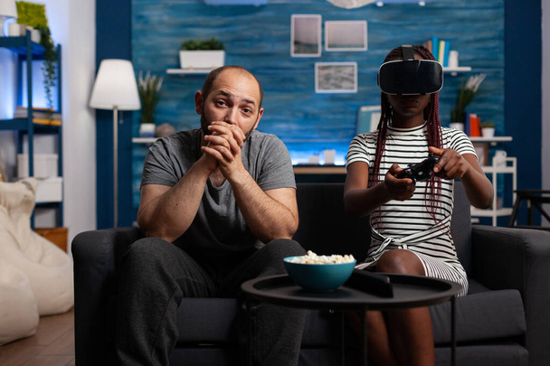 Fehér férfi nézi afro-amerikai nő játszik VR játék. - Fotó, kép