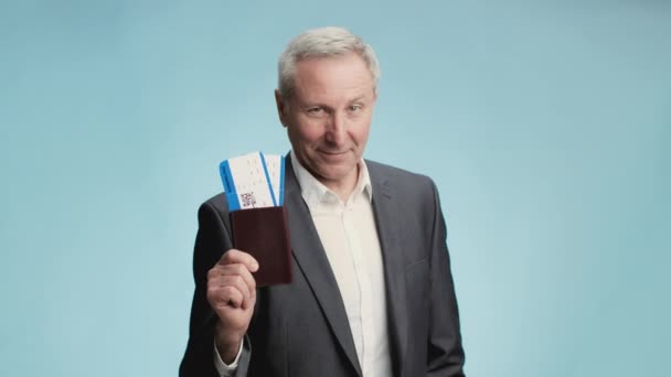 Üzleti út. Sikeres vezető üzletember, hivatalos viseletben, útlevéllel és repülőjegyekkel, kamerába mosolyogva - Felvétel, videó