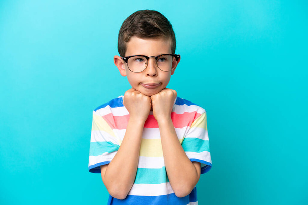 Kleiner Junge isoliert auf blauem Hintergrund Mit Brille und müde - Foto, Bild