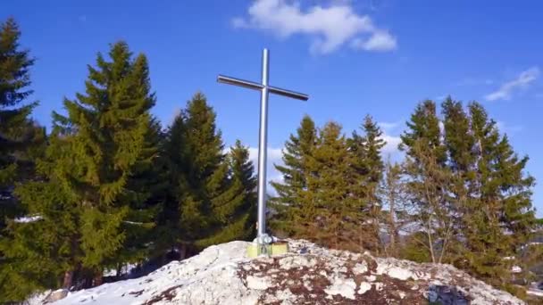Croix de fer chrétienne sur un rocher. Ciel bleu avec de petits nuages.Arbres en arrière-plan. Timelapse 4K - Séquence, vidéo