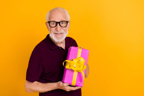 Photo of handsome mature man grandad hold receive gift festive isolated over yellow color background - 写真・画像
