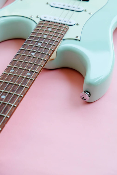 Detalle de la guitarra eléctrica verde menta sobre fondo rosa. - Foto, imagen