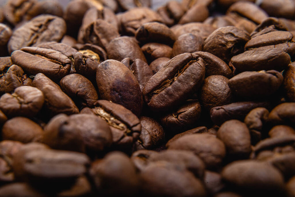 Coffee beans. Coffee beans are spread out on the surface. Roasted coffee beans background, pattern - Photo, Image