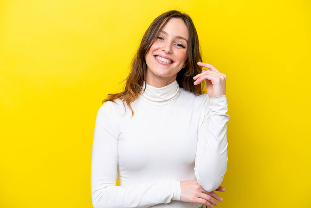 Young caucasian woman isolated on yellow background laughing - Photo, Image
