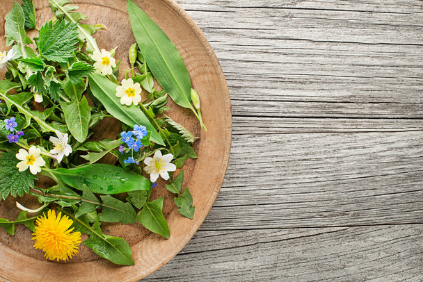 Healthy spring food ingredients. Dandelion, wild garlic and nettle in plate - Fotó, kép