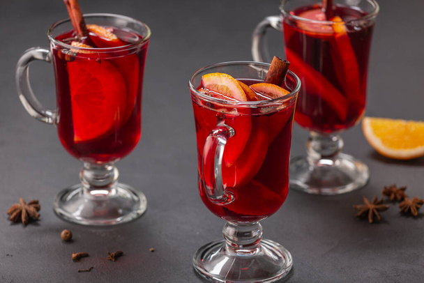 Alcoholic mulled wine with fruits and spices on a dark background, traditional alcoholic drink, Christmas - Photo, Image