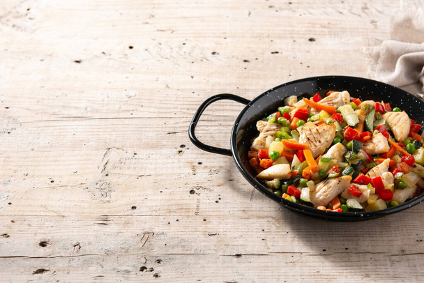 Chicken stir fry and vegetables on wooden table. Copy space - 写真・画像