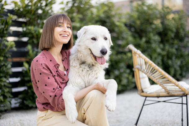 Muotokuva naisesta koiransa kanssa takapihalla - Valokuva, kuva