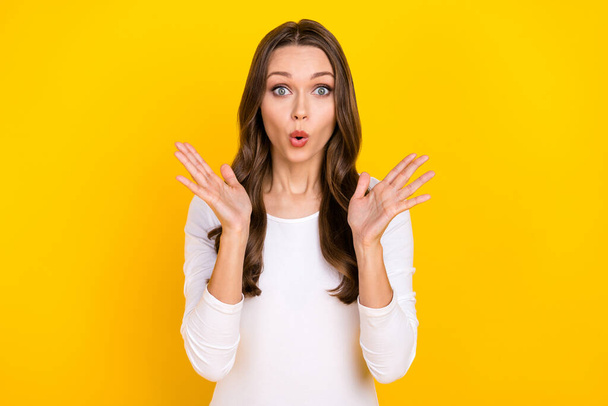 Photo of shocked crazy lady raise palms omg face reaction wear white shirt isolated yellow color background - Foto, Imagen