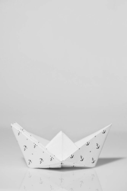white paper boat on a gray background - Foto, Bild