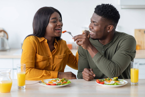 Szczęśliwy młody czarny małżonkowie korzystających z ich śniadanie w domu razem - Zdjęcie, obraz