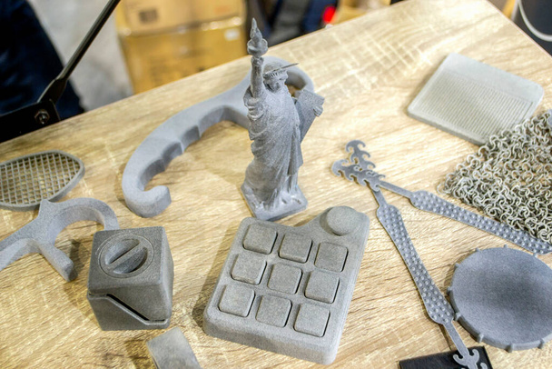 Molti modelli diversi stampati su stampante 3D. Oggetti grigi e neri stampati - Foto, immagini