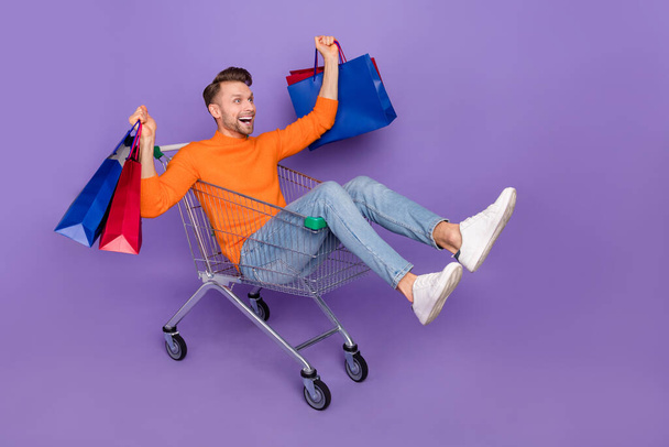 Full body photo of attractive overjoyed man excited to see huge bargains on black friday isolated on violet color background - Foto, Imagen