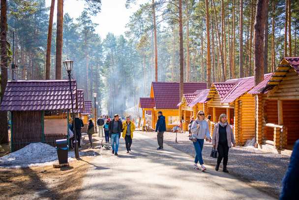 Kemerovo, Russia - April 16, 2022: People are walking in forest of open-air museum Tomsk pisanitsa located north-west of Kemerovo on the right bank of the Tom River in Siberia, Russia. - Foto, afbeelding