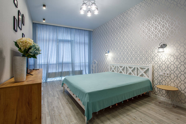 Εσωτερική φωτογραφία μοντέρνα κρεβατοκάμαρα σουίτα στο ξενοδοχείο με μεγάλο κομψό κρεβάτι, τηλεόραση και κούνια - Φωτογραφία, εικόνα